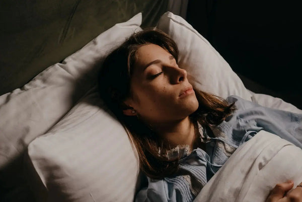 Woman sleeping peacefully on a Lunelle white silk pillowcase in soft morning light - evidence-based guide to silk pillowcase benefits for skin and hair