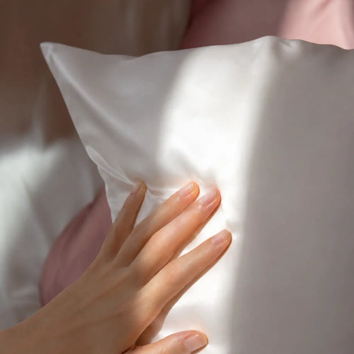 Close-up texture detail of Lunelle white 30 momme 100% mulberry silk pillowcase showing smooth weave
